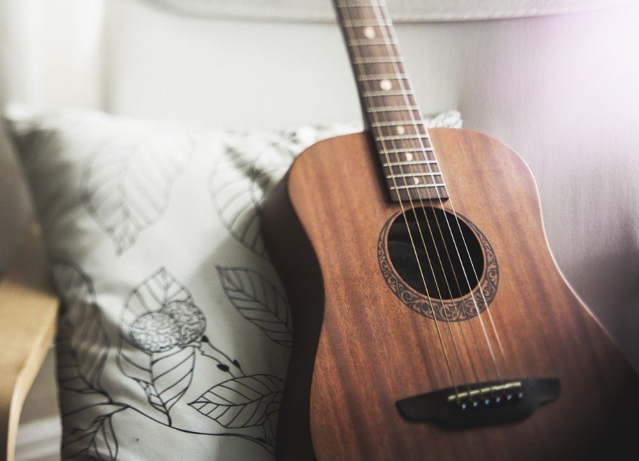 A guitar resting on a pillow, showing you that learning to play it is one of the best things to do in Dubai during the COVID-19 pandemic.