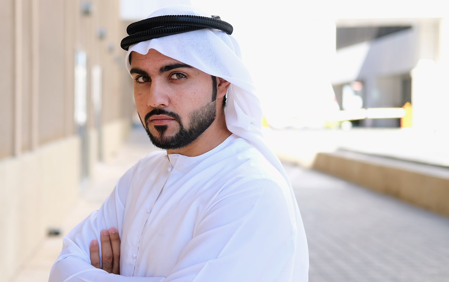 Portrait Of An Arab Emirati Man, Wearing Traditional Emirati Dress, Hanging  The Emblem Of The National Day Of The United Arab Emirates On His Chest